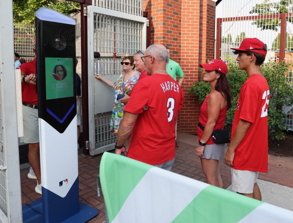 Football fans in a lively stadium scanning QR codes on their smartphones to unlock exclusive fan token perks and digital experiences in 2025